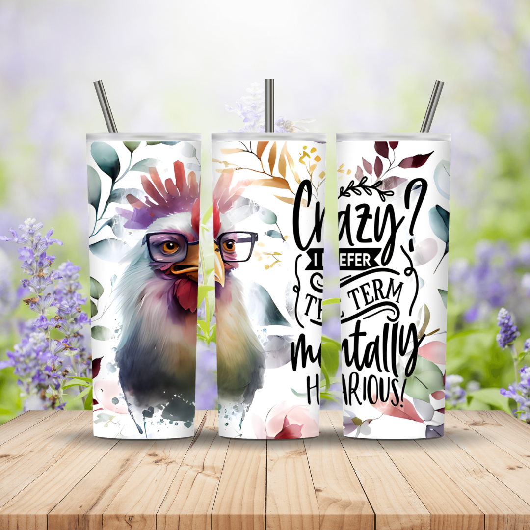 Three tumblers with rooster designs and text on a wooden surface with a floral background