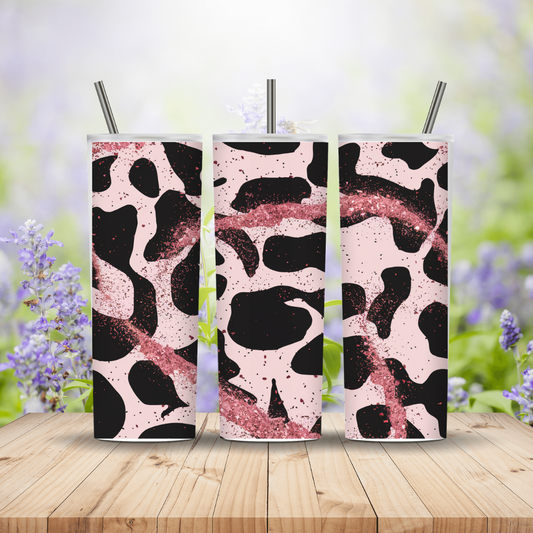Three tumblers with a black and pink abstract pattern on a wooden surface with a blurred floral background.