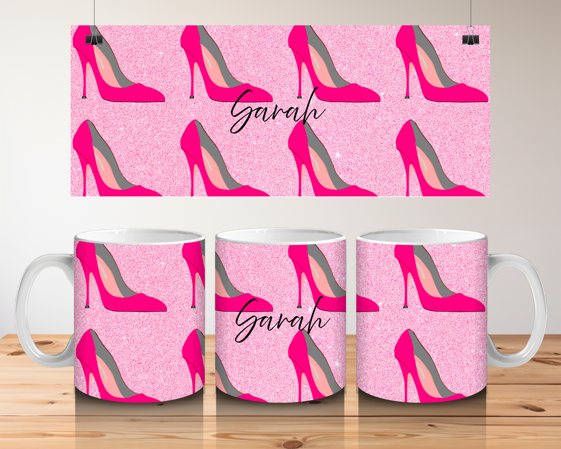 Mugs with pink high-heeled shoe pattern and 'Sarah' text on a wooden surface.