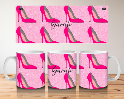 Mugs with pink high-heeled shoe pattern and 'Sarah' text on a wooden surface.