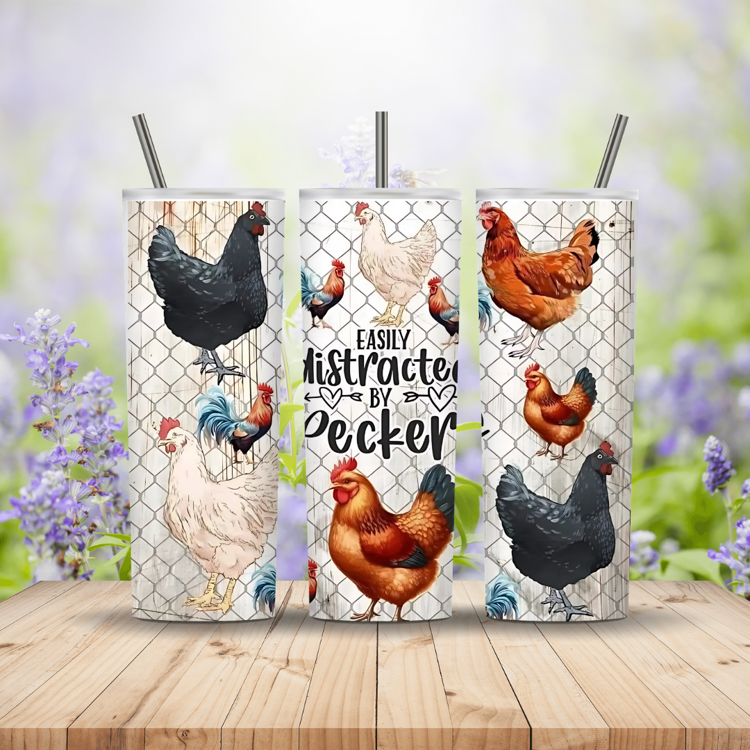 Three tumbler cups with chicken designs on a wooden surface with a blurred floral background.