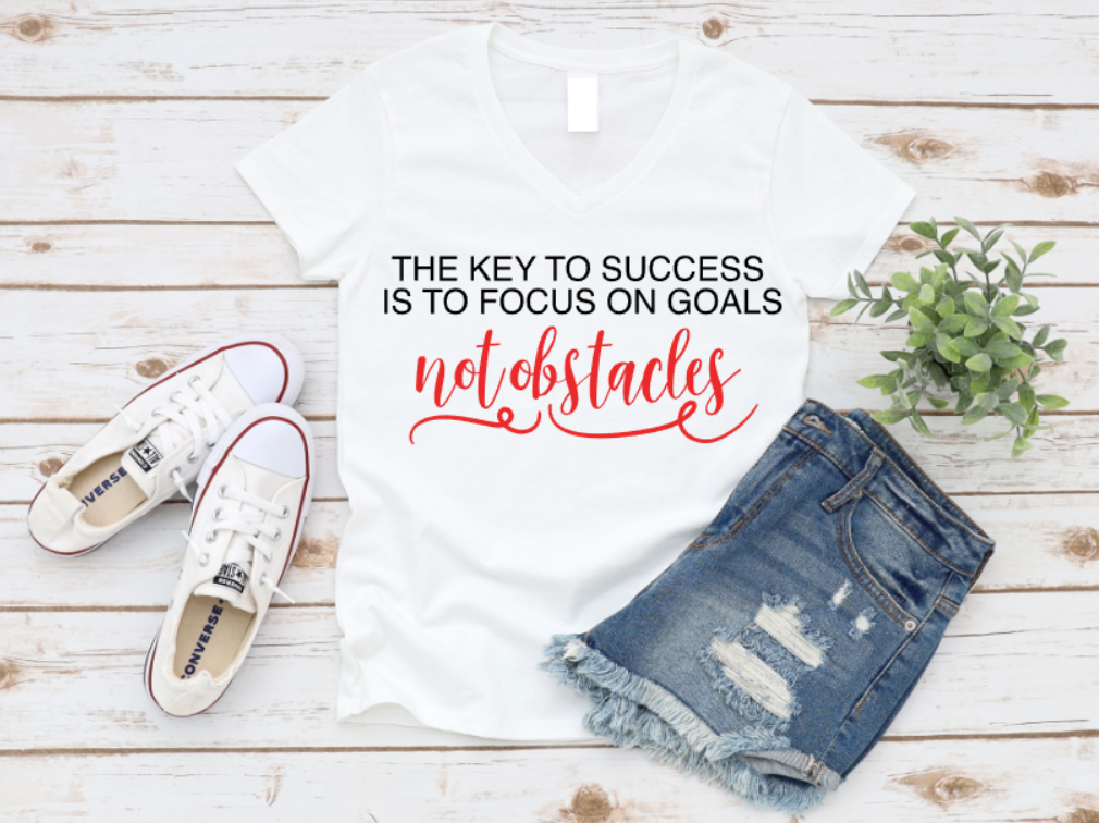 White t-shirt with motivational quote, white sneakers, and denim shorts on a wooden surface. www.missmafia.com
