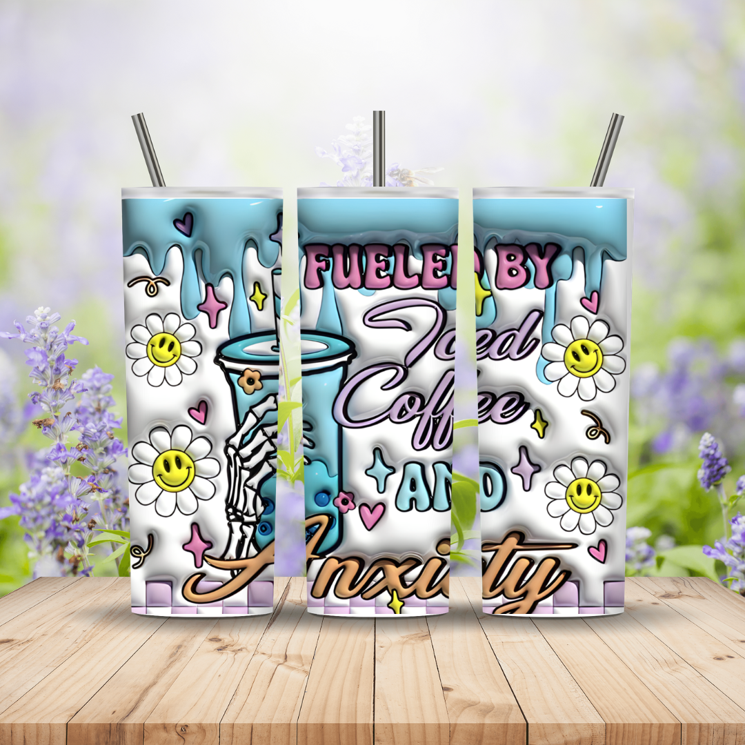Three colorful tumblers with floral and coffee-themed designs on a wooden surface with a blurred floral background.