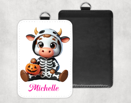 Card with a cartoon character in a cow costume and skeleton outfit, holding a pumpkin, with 'Michelle' written on it.