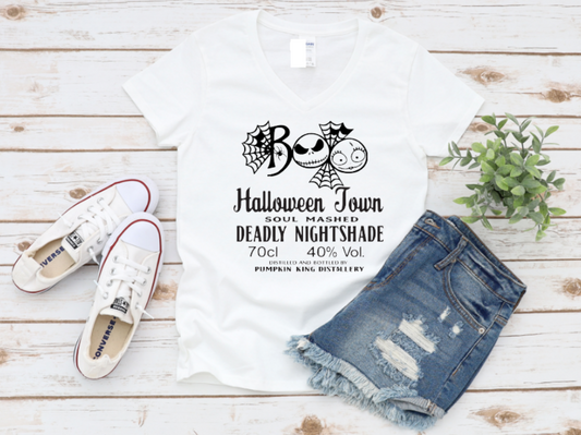 White t-shirt with "Boo" Halloween Town and Nightshade potion label design, styled with denim shorts and white sneakers on a wooden background.