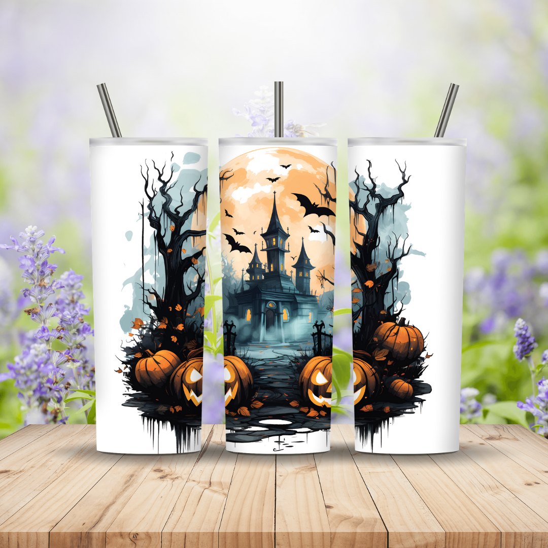 Three Halloween-themed tumblers with pumpkins and a castle design on a wooden surface.