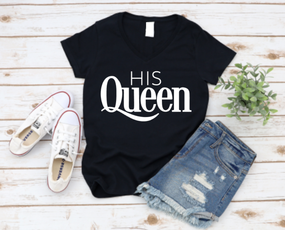 Black t-shirt with 'HIS Queen' text, white sneakers, and denim shorts on a wooden surface.
