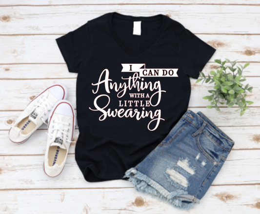 Black t-shirt with text, white sneakers, and denim shorts on a wooden surface