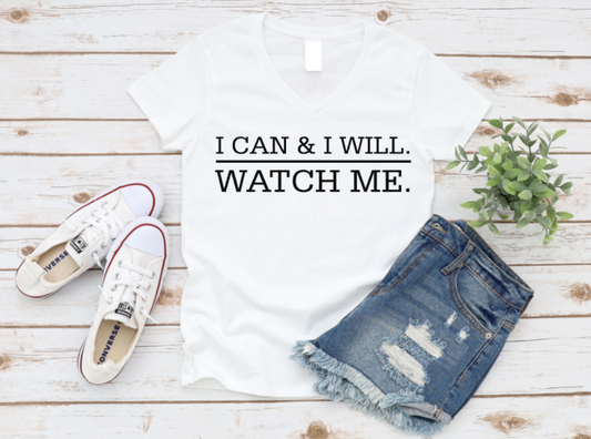 White t-shirt with motivational quote, white sneakers, and denim shorts on a wooden surface.