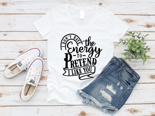 White t-shirt with black text, denim shorts, and white sneakers on a wooden surface.