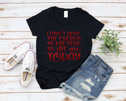 Black t-shirt with red text, white sneakers, and denim shorts on a wooden surface.
