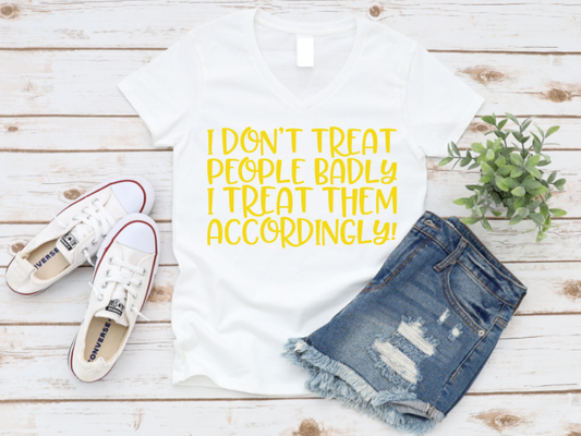 White t-shirt with yellow text, denim shorts, and white sneakers on a wooden surface.