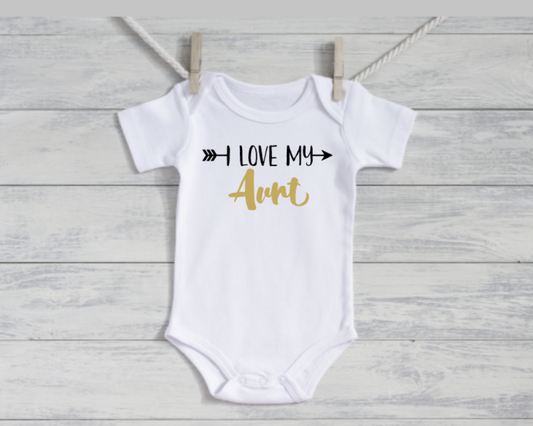 White baby onesie with 'I Love My Aunt' text on a wooden surface
