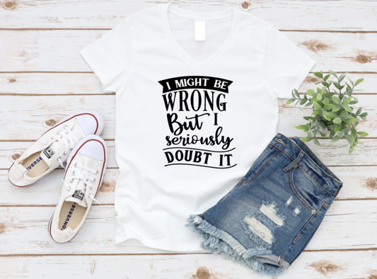 White t-shirt with humorous text, white sneakers, and denim shorts on a wooden surface.