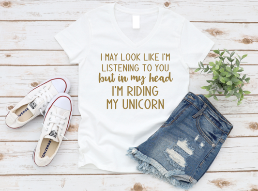White t-shirt with text, denim shorts, and white sneakers on a wooden surface.
