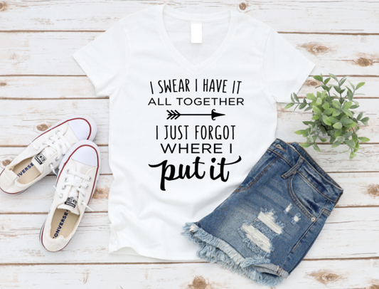 White t-shirt with humorous text, denim shorts, white sneakers, and a plant on a wooden surface. Shop at www.missmafia.com