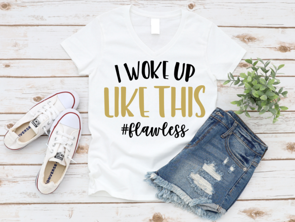 White t-shirt with 'I woke up like this #flawless' text, denim shorts, and white sneakers on a wooden surface. Shop at www.missmafia.com