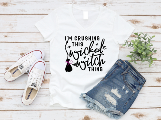 White t-shirt with 'I'm crushing this wicked witch thing' text, white sneakers, and denim shorts on a wooden surface. shop at www.missmafia.com