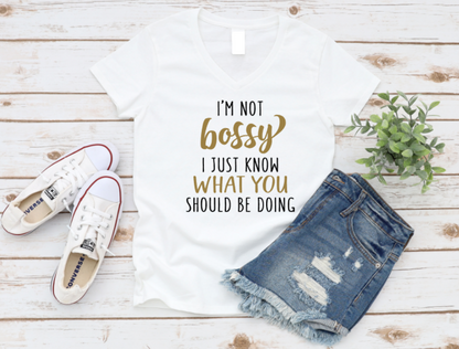 White t-shirt with 'I'm not bossy I just know what you should be doing' text, white sneakers, and denim shorts on a wooden surface. www.missmafia.com