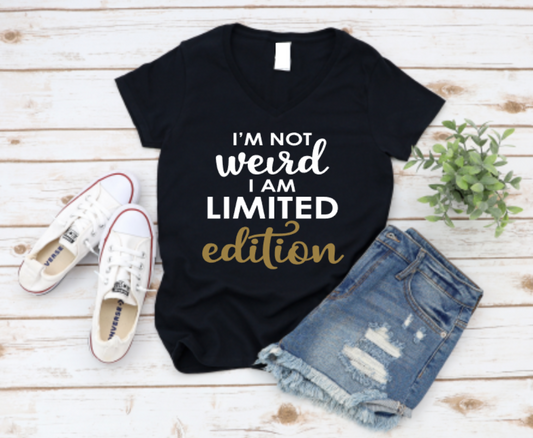 Black t-shirt with 'I'm not weird, I am limited edition' text on a wooden surface with shoes and shorts. www.missmafia.com