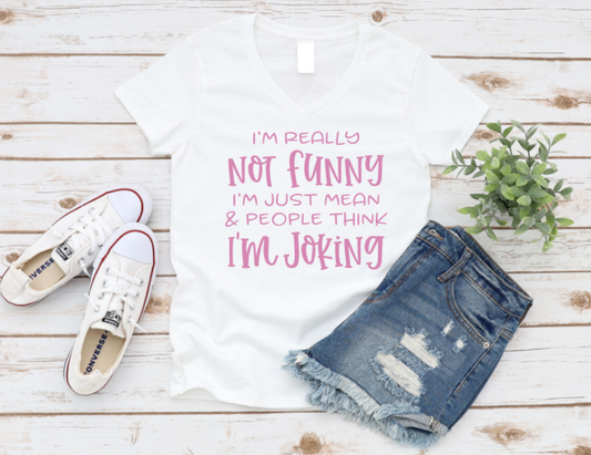 White t-shirt with pink text, denim shorts, and white sneakers on a wooden surface. www.missmafia.com