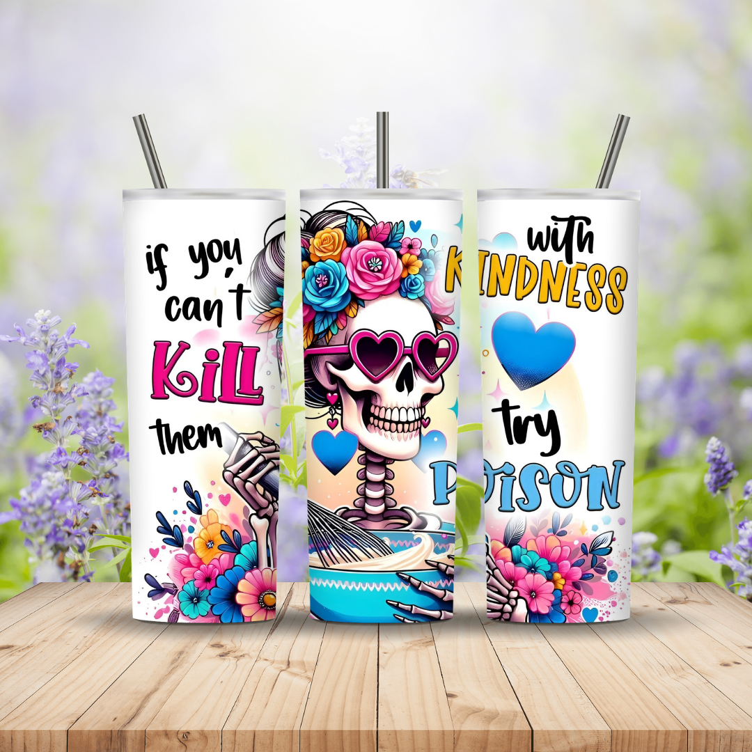 Three colorful tumblers with skull designs and motivational quotes on a wooden surface with a floral background.
