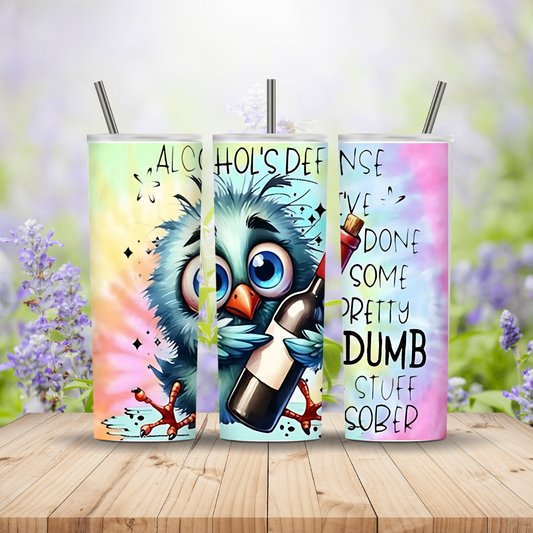 Three colorful tumblers with owl designs and text on a wooden surface with a blurred floral background.