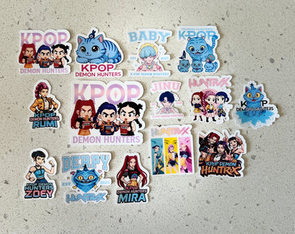 Collection of KPOP Demon Hunters stickers on a textured surface