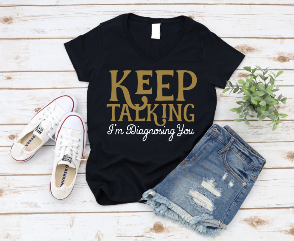 Black t-shirt with 'KEEP TALKING I'm Diagnosing You' text, paired with white sneakers and denim shorts on a wooden surface. www.missmafia.com