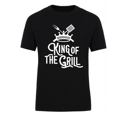 Black t-shirt with "King of the Grill" text design, featuring a crown, spatula, and meat fork – perfect for BBQ dads and grill masters.