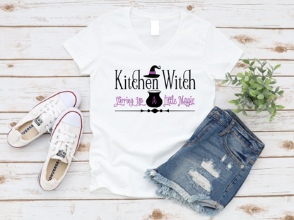 White t-shirt with 'Kitchen Witch' design, denim shorts, and white sneakers on a wooden surface. www.missmafia.com