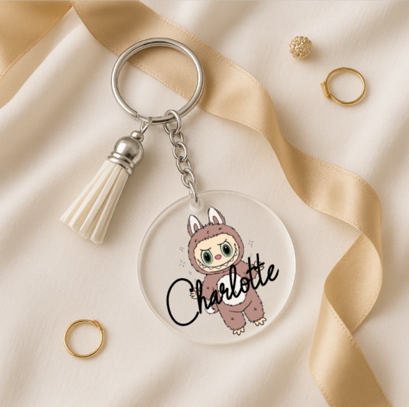 Keychain with cartoon character and 'Charlotte' text on a beige fabric background | www.missmafia.com