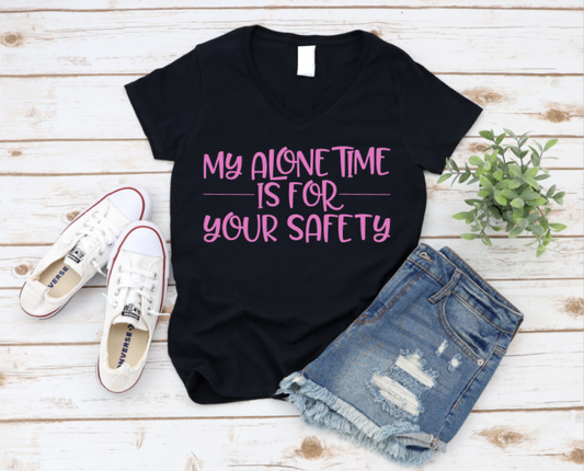 Black t-shirt with pink text 'My alone time is for your safety' on a wooden surface with shoes and shorts. www.missmafia.com