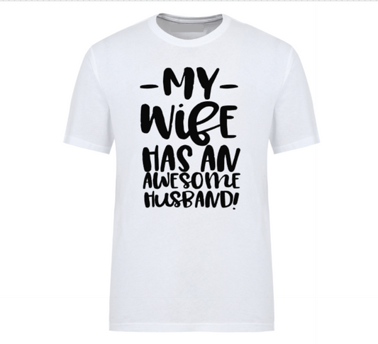 White t-shirt with bold black text that reads “My Wife Has an Awesome Husband,” displayed flat with casual jeans and white sneakers – a humorous gift idea for confident husbands.