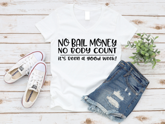 White t-shirt with humorous text, denim shorts, white sneakers, and a plant on a wooden surface. www.missmafia.com