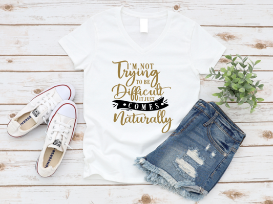 White t-shirt with humorous text design, paired with denim shorts and white sneakers on a wooden surface.