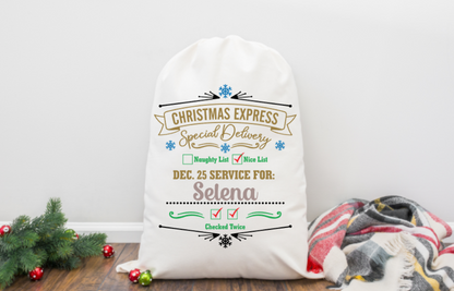 Personalized Christmas sack with decorative text on a wooden floor with a blanket and tree.
