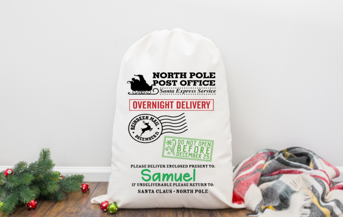 Personalized Santa sack from North Pole Post Office with festive design on a wooden surface.