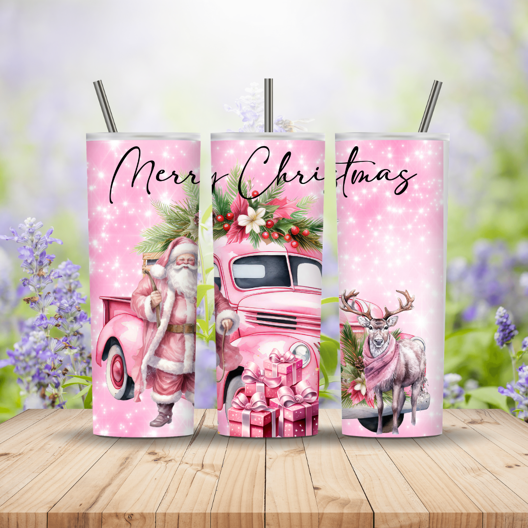 Three pink tumblers with Christmas designs on a wooden surface with a blurred floral background.