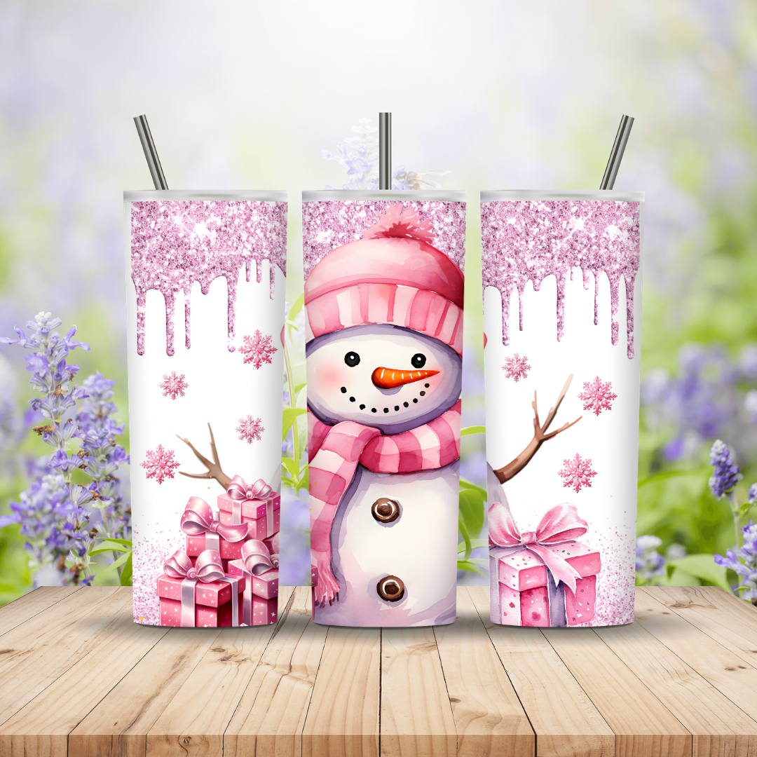 Three tumblers with a snowman design on a wooden surface with a blurred floral background