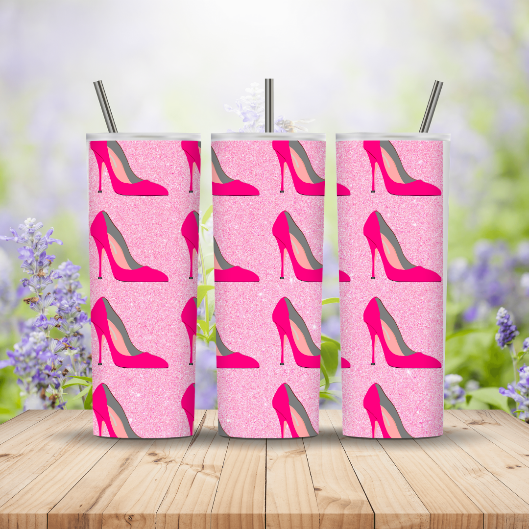 Three pink tumblers with high heel shoe pattern on a wooden surface with a blurred floral background Miss Mafia