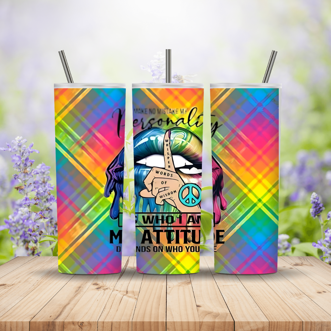 Three colorful tumblers with artistic designs and text on a wooden surface with a blurred floral background.