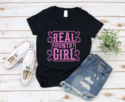 Black t-shirt with 'Real Country Girl' text, paired with denim shorts and white sneakers on a wooden surface. www.missmafia.com