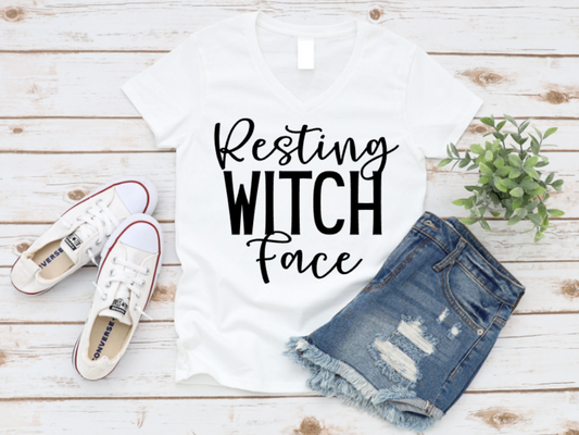 White t-shirt with 'Resting Witch Face' text, denim shorts, and white sneakers on a wooden surface. www.missmafia.com