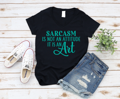 Black t-shirt with 'Sarcasm is not an attitude, it is an art' text on a wooden surface with shoes and shorts. www.missmafia.com