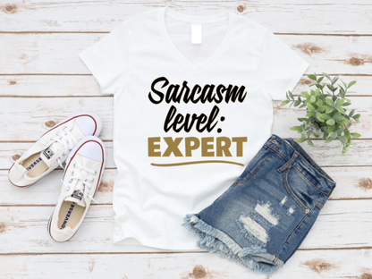 White t-shirt with 'Sarcasm level: Expert' text, denim shorts, and white sneakers on a wooden surface. www.missmafia.com