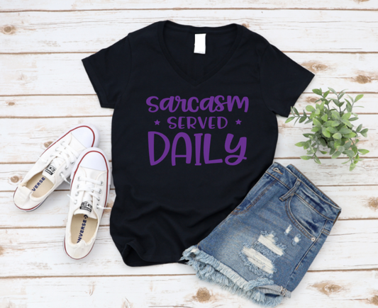 Black t-shirt with 'sarcasm served daily' text, paired with denim shorts and white sneakers on a wooden surface. www.missmafia.com