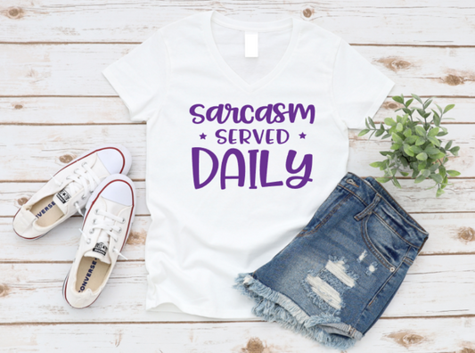 White t-shirt with 'sarcasm served daily' text, white sneakers, and denim shorts on a wooden surface. www.missmafia.com