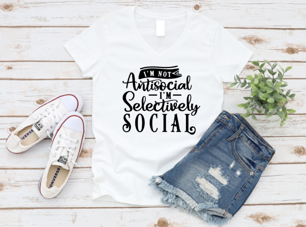 White t-shirt with 'I'm not antisocial, selectively social' text, paired with denim shorts and white sneakers on a wooden surface. www.missmafia.com