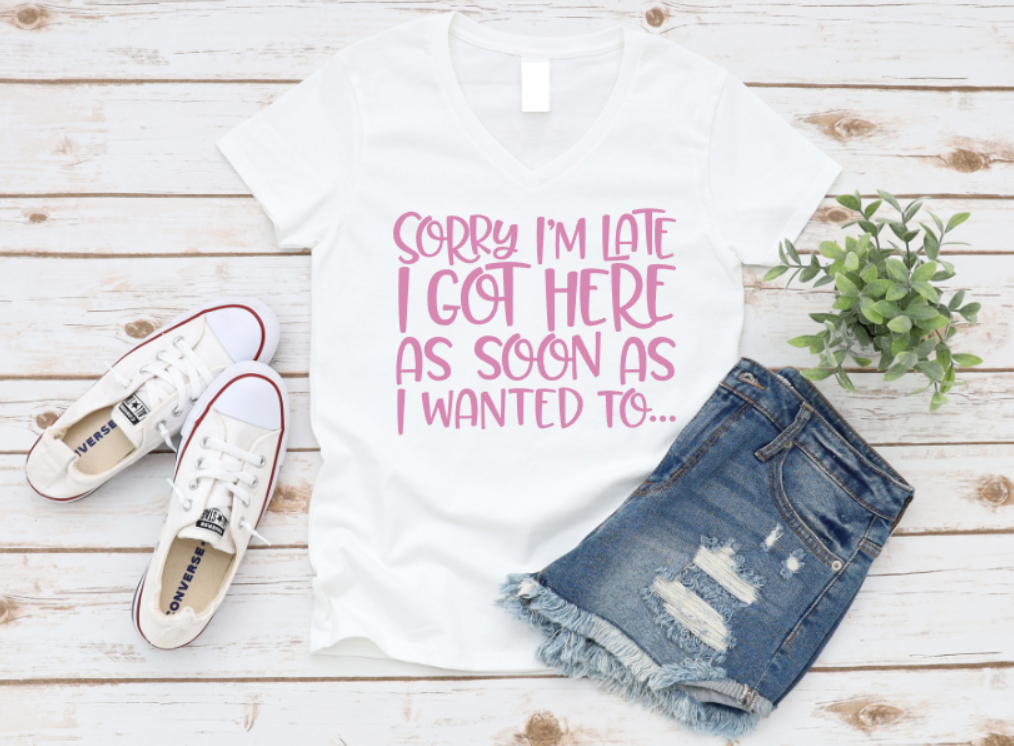 White t-shirt with pink text, white sneakers, and denim shorts on a wooden surface. www.missmafia.com